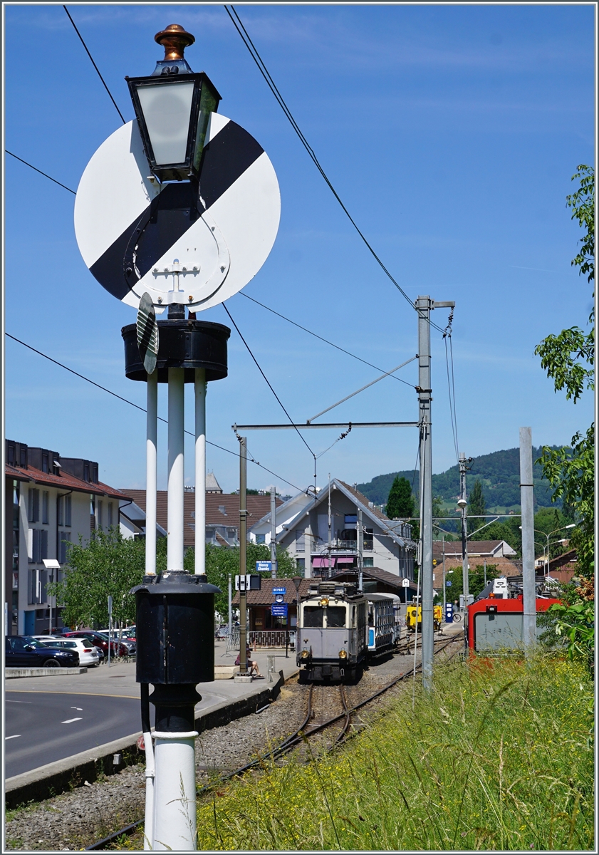 Der LLB (Leuk - Leukerbad Bahn 1915 - 1967) Triebwagen mit der phantasievollen Bezeichnung ABFe 2/4 N° 10 wartet im Blonay seinem Zug nach Chamby auf die Abfahrt, das Ausfahtsignal, eine die Hippsche Wendescheibe, zeigt dem Zug jedoch noch nicht Freie Fahrt.

21. Mai 2022