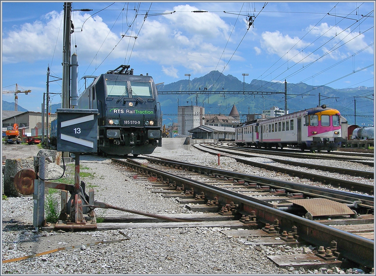 Die RTS Re 185 570-9 in Bulle, im Hintergrund verlässt ein (ex MThB) Pendelzug den Bahnhof Richtung Romont.
19. Juni 2017