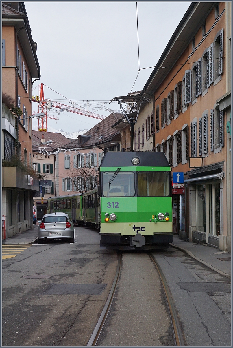 Immer wieder eindrücklich, die Ortsdurchfahrt der A-L in Aigle! 
Der BDeh 4/4 312 schiebt seine beiden Bt Richtung Aigle Bahnhof.
7. Jan. 2018