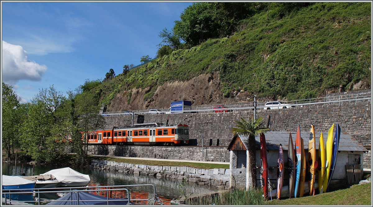 Kurz vor Agno fährt dieser FLP Regionalzug Richtng Lugano an einem Bootshaus mit bunten Kanus vorbei. 
30. April 2015