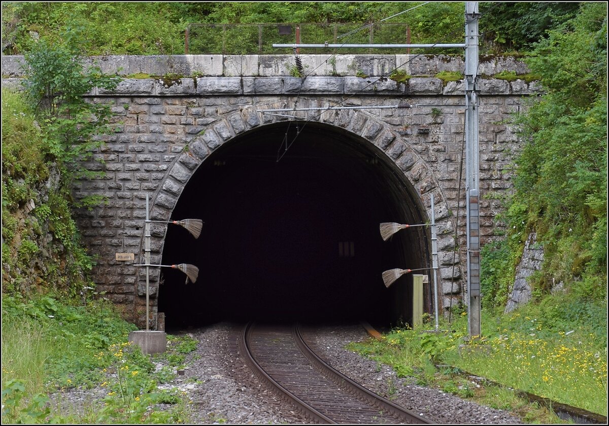 Mal eine technische Kuriosit�t statt bunter Bilder.

Die Strecke von Neuenburg nach La Chaux-de-Fonds brauchte einen langen Scheiteltunnel unter dem Col de la Vue des Alpes. Da offenbar einfacher zu realisieren, gab es in Convers einen Zwischenangriff und eine leicht verl�ngerte Strecke. Hier das Tunnelportal des Des Loges Tunnels. Dann folgt eine 125 m lange Kurve in den n�chsten Tunnel. Les Convers, Juli 2018.

Vom anderen Tunnelportal zeigt Stefan eine Aufnahme: http://igschieneschweiz.startbilder.de/bild/schweiz~e-loks~re-465-bls-2/711292/die-bls-re-465-002-ist.html