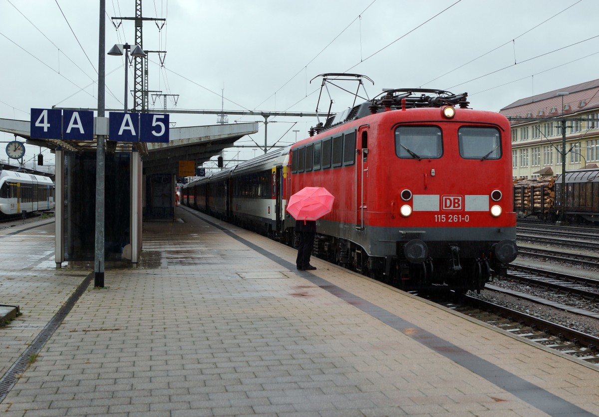 SBB/DB: Fotografieren in Singen am 20. November 2015 trotz starkem Wind und Dauerregen. Der IC Z�rich - Stuttgart mit der 115 261-0 stand auf Gleis 5 zur Abfahrt bereit. Der Lokf�hrer w�hrend der Entgegennahme der letzten Hinweise durch den Zugschef der Deutschen Bahn mit unpassendem Schirm.
Foto: Walter Ruetsch 