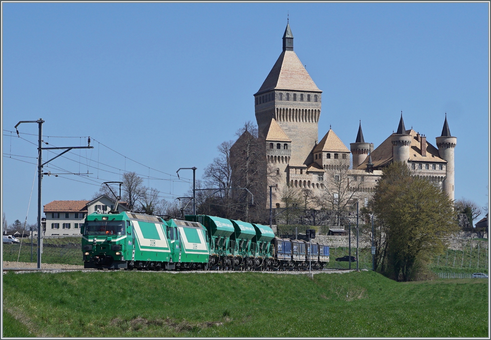 Die beiden BAM MBC Ge 4/4 21 und 22 sind mit ihrem Kieszug Apples - Morges - Gland bei Vufflens le Château unterwegs. Den Hintergrund prägt das zauberhafte Schloss von Vufflens. 

5. April 2023