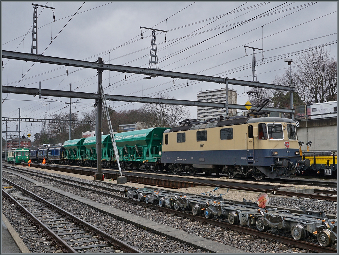 Die IRSI Re 4/4 II 11387 (Re 421 387-2) z.Z. im Dienste der BAM MBC schiebt in Morges  langsam ihrem Kieszug auf die Rollbockgrube. Der Güterzug wird in der Folge von den beiden BAM MBC Ge 4/4 21 und 22 für die Weiterfahrt nach Apples übernommen. 

22. Februar 2024 