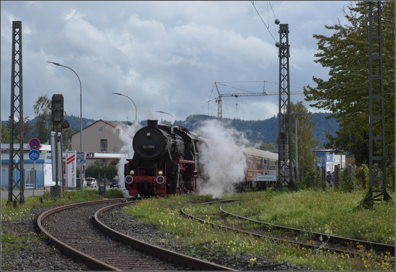 Schienenverkehr unterm Hohentwiel. 

52 7596 mit ihrem EFZ-Sonderzug für die SEHR & RS wartet am Einfahrtsignal des Bahnhof Singen, nachdem sie mir beim letzten Bahnübergang Ostendstrasse entwischt war. Oktober 2022.