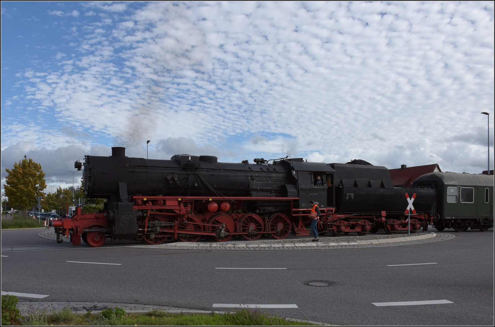 Schienenverkehr unterm Hohentwiel. 

52 7596 mit ihrem EFZ-Sonderzug für die SEHR & RS auf der dritten Station der Bahnübergangsralley in Singen mitten auf dem Kreisverkehr der Georg-Fischer-Strasse. Oktober 2022.