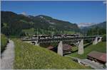 Der von Sarah Morris gestaltete MOB Lenkerpendel  Monarch  ABt 341 - Be 4/4 5001 - Bt 241 als Regionalzug 2531 Lenk - Rougemont auf dem 109 Meter langen Grubenbachviadukt kurz vor der Ankunft in